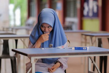 Muadzam Shah, Malaysia - April 7th, 2022 : Lateral-Flow-Test covid rapid home-use test kit for saliva - step 2 - spit with mouth through funnel in plastic tube to collect sample.
