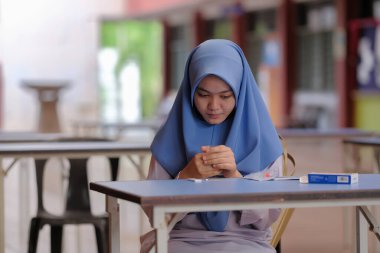 Muadzam Shah, Malaysia - April 7th, 2022 : Lateral-Flow-Test covid rapid home-use test kit for saliva - step 2 - spit with mouth through funnel in plastic tube to collect sample.