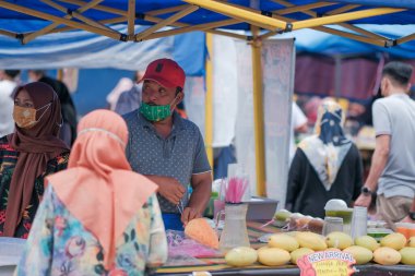 Muadzam Şah, Malezya - 8 Nisan 2022: Muadzam Şah 'taki kutsal Ramazan ayında yol kenarındaki tezgahtan helal yiyecekler pişiren ve satan Müslüman erkek satıcılar.