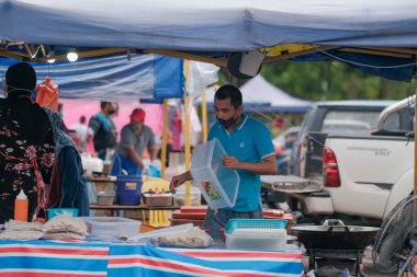 Muadzam Şah, Malezya - 8 Nisan 2022: Muadzam Şah 'taki kutsal Ramazan ayında yol kenarındaki tezgahtan helal yiyecekler pişiren ve satan Müslüman erkek satıcılar.
