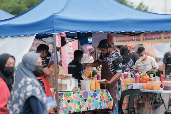 Muadzam Şah, Malezya - 8 Nisan 2022: Muadzam Şah 'taki kutsal Ramazan ayında yol kenarındaki tezgahtan helal yiyecekler pişiren ve satan Müslüman erkek satıcılar.