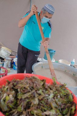 Muadzan Şah, Malezya - 16 Nisan 2022: Bubur Lambuk adlı lezzetli geleneksel lapayı pişirmeye, hazırlamaya ve dağıtmaya yardım eden gönüllüler.