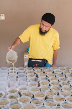 Muadzam Şah, Malezya - 16 Nisan 2022: Bubur Lambuk adlı lezzetli geleneksel lapayı pişirmeye, hazırlamaya ve dağıtmaya yardım eden gönüllüler.