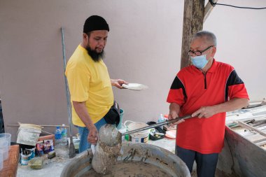 Muadzam Şah, Malezya - 16 Nisan 2022: Bubur Lambuk adlı lezzetli geleneksel lapayı pişirmeye, hazırlamaya ve dağıtmaya yardım eden gönüllüler.