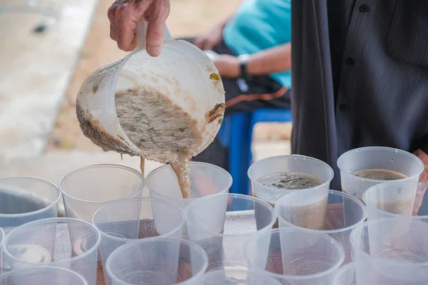 Muadzan Şah, Malezya - 16 Nisan 2022: Bubur Lambuk adlı lezzetli geleneksel lapayı pişirmeye, hazırlamaya ve dağıtmaya yardım eden gönüllüler.