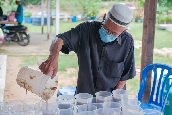 Muadzan Şah, Malezya - 16 Nisan 2022: Bubur Lambuk adlı lezzetli geleneksel lapayı pişirmeye, hazırlamaya ve dağıtmaya yardım eden gönüllüler.