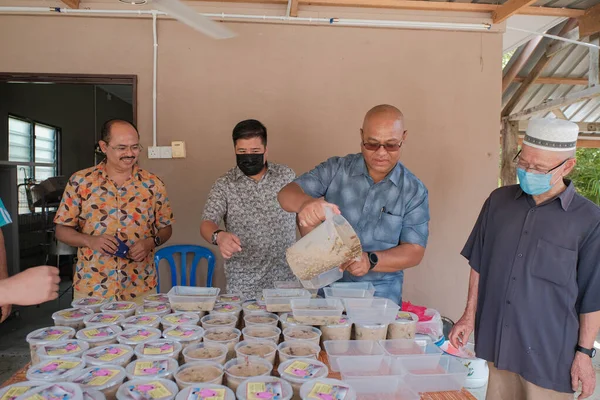 Muadzam Şah, Malezya - 16 Nisan 2022: Bubur Lambuk adlı lezzetli geleneksel lapayı pişirmeye, hazırlamaya ve dağıtmaya yardım eden gönüllüler.