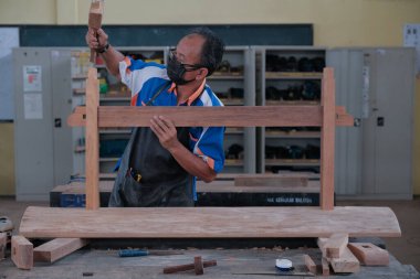 Üst düzey erkek marangoz atölyede konsol masası yapıyor. Ahşap mobilya üretiminde doğrama işi. Küçük İş Konsepti