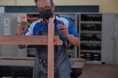 Üst düzey erkek marangoz atölyede konsol masası yapıyor. Ahşap mobilya üretiminde doğrama işi. Küçük İş Konsepti