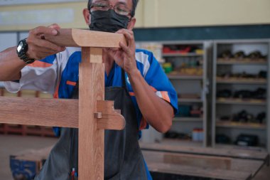 Üst düzey erkek marangoz atölyede konsol masası yapıyor. Ahşap mobilya üretiminde doğrama işi. Küçük İş Konsepti