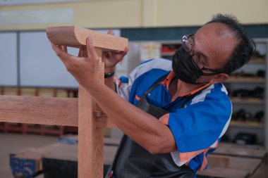 Üst düzey erkek marangoz atölyede konsol masası yapıyor. Ahşap mobilya üretiminde doğrama işi. Küçük İş Konsepti