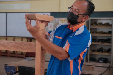 Üst düzey erkek marangoz atölyede konsol masası yapıyor. Ahşap mobilya üretiminde doğrama işi. Küçük İş Konsepti