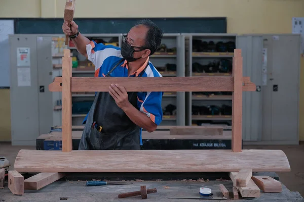 Üst düzey erkek marangoz atölyede konsol masası yapıyor. Ahşap mobilya üretiminde doğrama işi. Küçük İş Konsepti