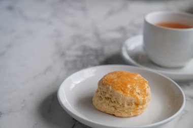 Çörekli çay, pıhtılaşmış krema, reçel, beyaz masada çilek.