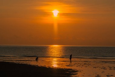 Gün doğumuna karşı yürüyen çift silueti.