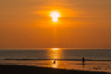 Gün doğumuna karşı yürüyen çift silueti.