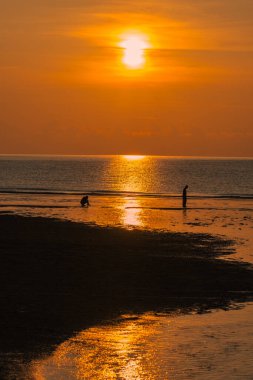 Gün doğumuna karşı yürüyen çift silueti.