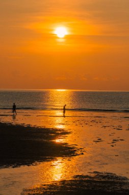 Gün doğumuna karşı yürüyen çift silueti.