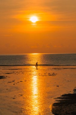 Gündoğumuna karşı yürüyen adamın silueti.