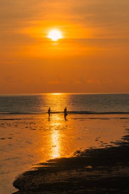 Gün doğumuna karşı yürüyen çift silueti.