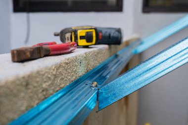 Roofer screwing down the steel roof battens