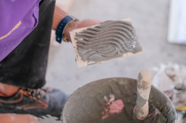College students  laying ceramic tiles on the wall  in bricklaying workshop