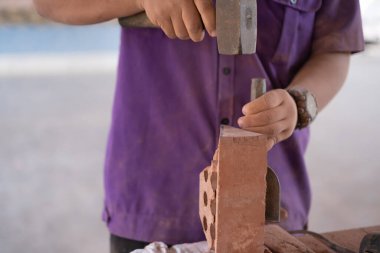 Üniversite öğrencileri tuğla örme atölyesinde tuğla duvar inşaatında çalışıyor.