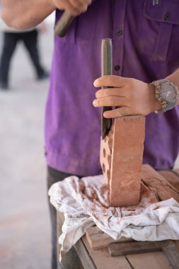 Üniversite öğrencileri tuğla örme atölyesinde tuğla duvar inşaatında çalışıyor.