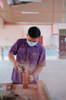 Muadzam Shah, Malaysia - August 25th, 2022: College students  working brick wall construction in bricklaying workshop