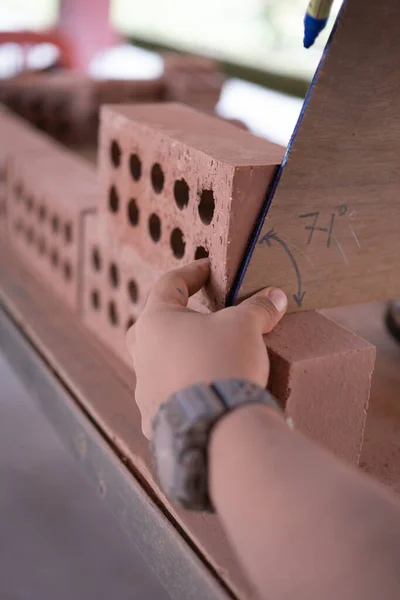 College students  working brick wall construction in bricklaying workshop