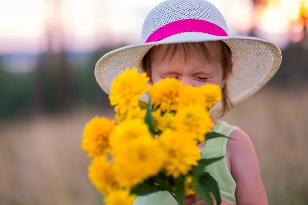 Girl sniffs flowers — Stock Photo, Image