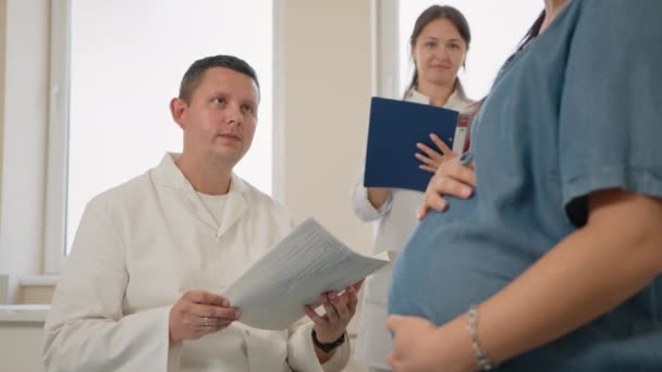 Ginecólogo masculino consultando a mujer embarazada en clínica — Vídeos de Stock