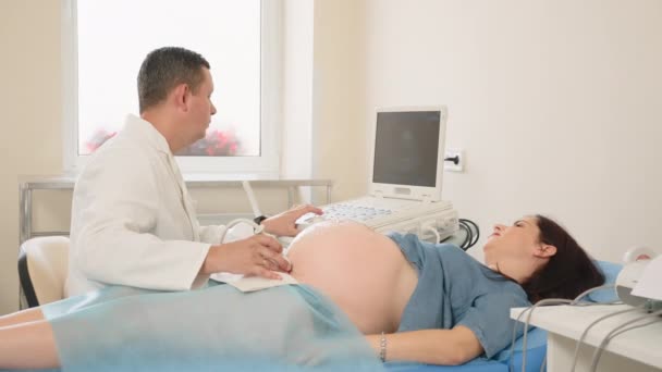 Médecin scanner le ventre de la femme enceinte avec échographie — Video