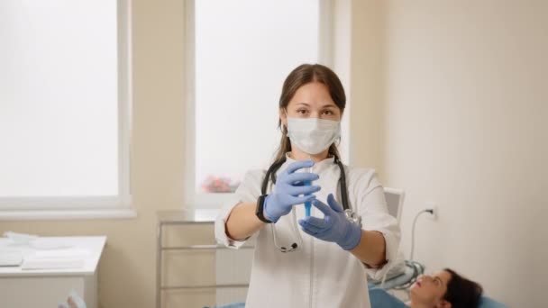 Arts staat in de buurt van zwangere vrouw met spuit in handen — Stockvideo