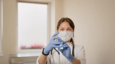 Doktorlar ellerinde şırıngayla aşıyı hastanede tutuyorlar. Sağlık ve tıbbi kavramlar. Bilim adamı şırıngadan ebola aşısı dolduruyor. Doktor mikrobiyolog laboratuvarda araştırmacı bilim adamı.
