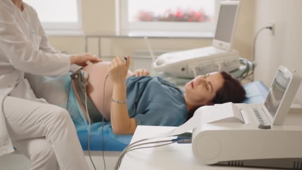 Гінеколог перевіряє серцебиття плоду вагітної жінки — стокове відео