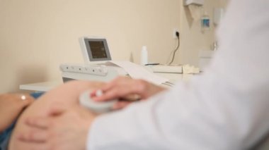 Doktor hamile bir kadının bebek kalp atışlarını izliyor.