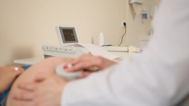 Lekarz monitorujący bicie serca dziecka kobiety w ciąży — Wideo stockowe