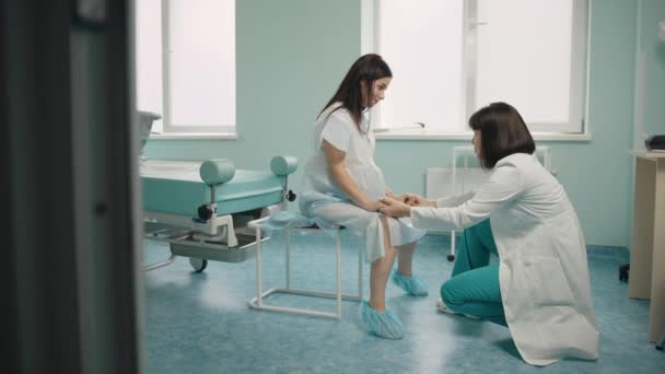 İşçilerden önce hamile bir kadını destekleyen sağlık çalışanı — Stok video
