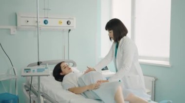 Doktor, hamile bir kadının doğum öncesi kalp atışlarını kontrol ediyor.