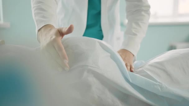 Гинеколог щупает животик беременной женщины. Врач проверяет сердечный ритм беременной женщины перед родами — стоковое видео