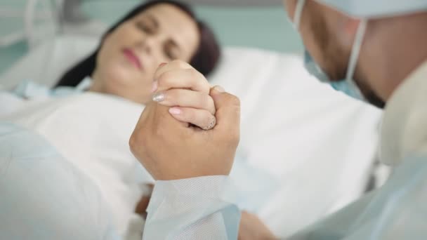 Close-up on a Face of a Woman in Labor Pushing Hard to Give Birth, Obstetricians Assisting, Spouse Holds Her Hand. Modern Maternity Hospital with Professional Midwives — Stock Video