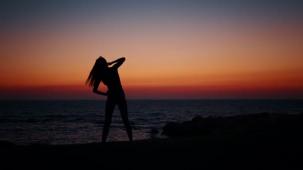 身披轮廓的女人在大海边练习健身 — 图库视频影像