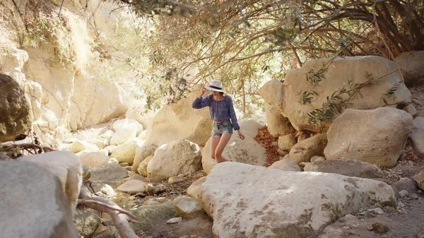 Affascinante donna in abiti estivi a piedi tra alte rocce — Foto Stock