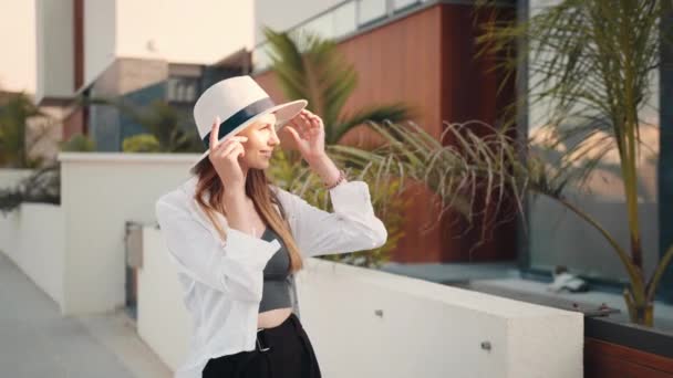 Vrouw met zomerhoed glimlacht oprecht op camera buiten — Stockvideo
