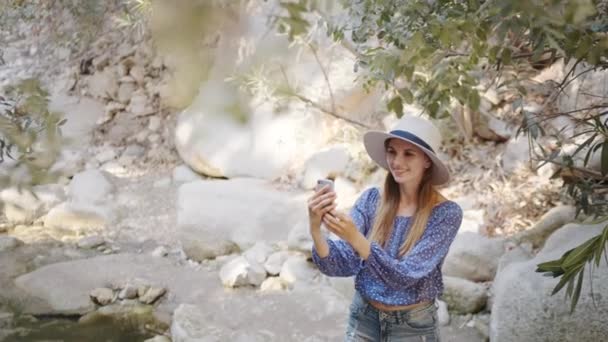 Туристичний блогер записує відео на мобільному серед каменів — стокове відео