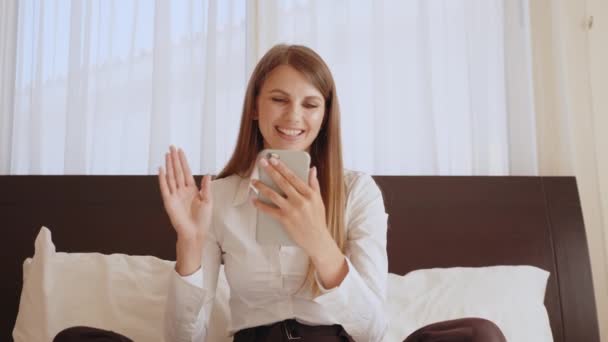 Pozytywna kobieta na telefonie komórkowym w pokoju hotelowym — Wideo stockowe