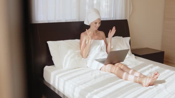 Kobieta w ręczniku mając rozmowę wideo na laptopie w pokoju hotelowym — Wideo stockowe