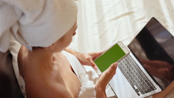Pani korzystająca z laptopa i telefonu komórkowego z ekranem chroma key w hotelu — Wideo stockowe