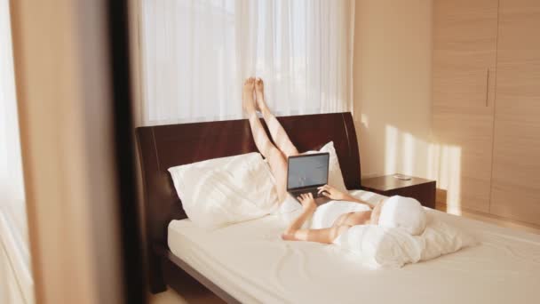 Kobieta odpoczywająca w pokoju hotelowym i korzystająca z laptopa — Wideo stockowe